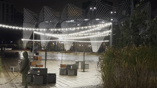 Minsk Belarus October 15 2025 Woman walking dog at night, in evening under string lights in rainy