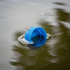 Close-Up of Plastic Water Bottle Cap Floating in River Pollution Environmental Concept