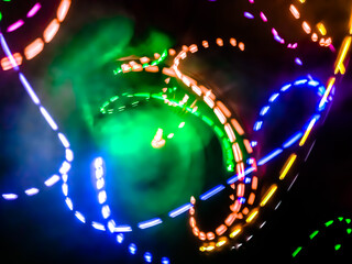 Colorful light particles form digital curves and dots in a light painting effect, creating an energetic and futuristic background.