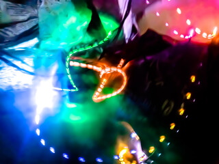 Colorful light particles form digital curves and dots in a light painting effect, creating an energetic and futuristic background.