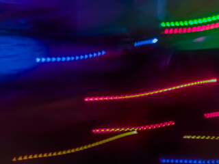 Elegant neon colored lines of light cut through the darkness of the night, giving a futuristic and dynamic impression of speed and movement, like a stunning digital abstract painting