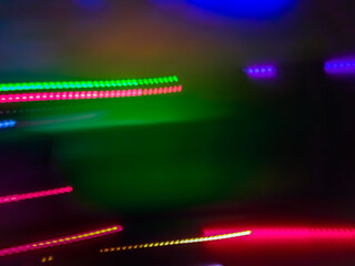 Elegant neon colored lines of light cut through the darkness of the night, giving a futuristic and dynamic impression of speed and movement, like a stunning digital abstract painting