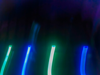 Elegant neon colored lines of light cut through the darkness of the night, giving a futuristic and dynamic impression of speed and movement, like a stunning digital abstract painting