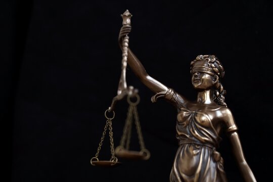 Lady Justice female statue on black backdrop. Law and justice concept