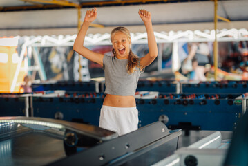 Excited girl celebrating winning an arcade game at amusement park