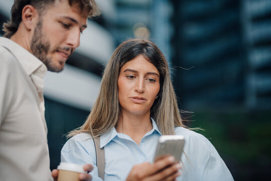 Businesspeople using mobile phone outdoor in the city