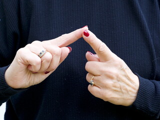 A pair of hands signing the vowel letter 'E'  in British Sign Language.BSL.Communication.Hearing Impaired.