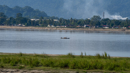 Traditional Indian canoe or boat with fisherman at river Brahmaputra Assam India 1