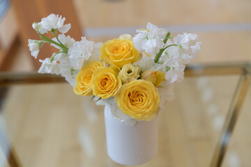 yellow roses and white Matthiola incana arrangement indoors