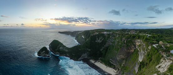 coastal sunset scene, serene oceanfront scenery during twilight featuring cliffs and calm sea Nusa Penida Kelingking Beach Bali 