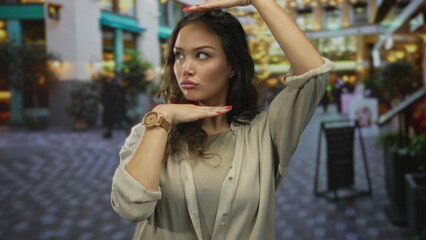 Fototapeta premium Hispanic woman performs framing gesture with hands on bustling street; creativity imagination perspective vision.