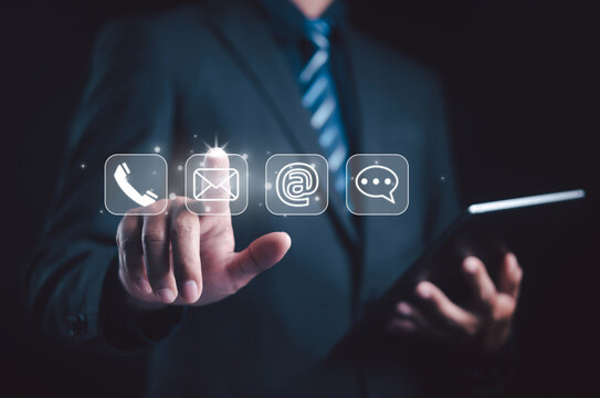 Businessman touching virtual contact icons including phone, email, and chat symbols, representing communication, customer service, digital connection, and business technology interaction concept.