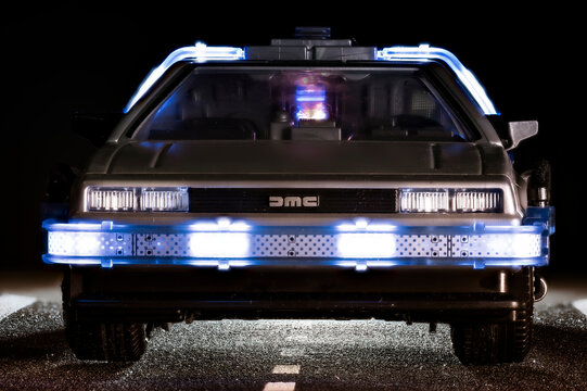 Madrid, Spain; October 25, 2025: Close-up front view of a Playmobil DeLorean toy inspired by Back to the Future, illuminated with blue LED lights on a dark background