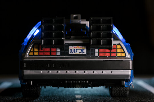 Madrid, Spain; October 25, 2025: Rear view of a Playmobil DeLorean toy featuring the iconic OUTATIME license plate, glowing blue lights and dark cinematic lighting