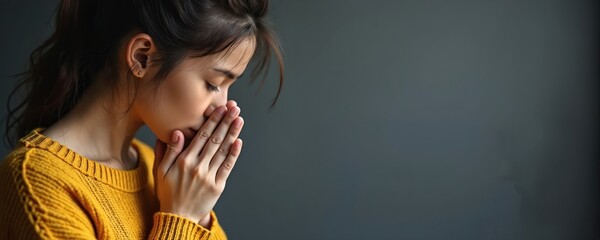 Young woman with hands clasped in prayer. Closes eyes seeking solace giving thanks. Devout pose conveys deep spirituality, quiet introspection. Gentle lighting thoughtful expression, offering sense
