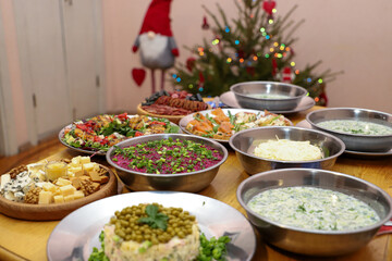 Olivier salad, sandwiches, canapés, bruschetta. A Christmas scene with meat delicacies against a dark wood background. An assortment of cheese and meat appetizers.