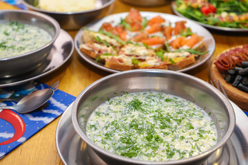 Olivier salad, sandwiches, canapés, bruschetta. A Christmas scene with meat delicacies against a dark wood background. An assortment of cheese and meat appetizers.