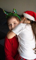 Sisters in Christmas pajamas hug each other