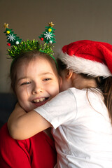 Sisters in Christmas pajamas hug each other