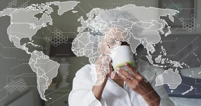 Senior woman lifting mug, sipping and reflecting as faint world map overlay reveals face for health