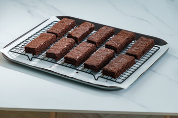 many chocolate brownies in baking tray on white table