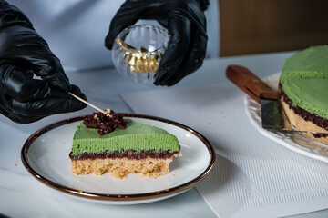 a hand of chef do working as dressing the face of a piece of cake in catering cuisine