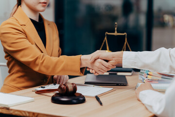 Deal of Justice: A focused shot of two individuals shaking hands to seal a legally binding deal,...