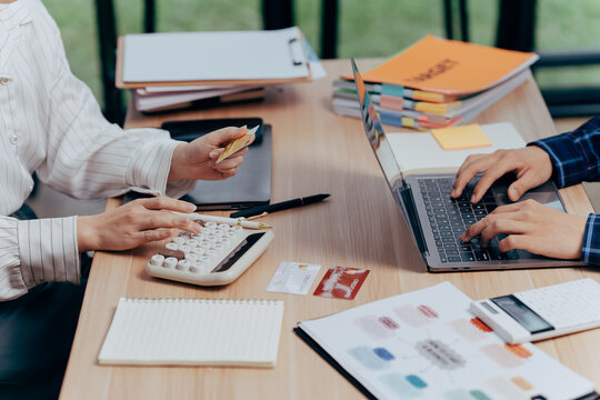 Financial Synergy: Two individuals collaborate closely at a wooden desk, engrossed in analyzing financial documents, managing the budget, and making critical decisions.