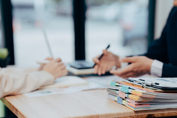 Business Consultation: In a sunlit office, two professionals engage in a focused consultation. A...