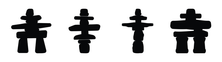 Four inukshuks symbols standing together representing inuit culture and navigation markers