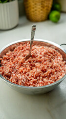 Raw ground meat in metal bowl with fork, overhead view. Fresh minced beef perfect for cooking and recipe content. Professional food photography for culinary, meal prep, and kitchen themes.