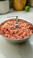 Raw ground meat in metal bowl with fork, overhead view. Fresh minced beef perfect for cooking and recipe content. Professional food photography for culinary, meal prep, and kitchen themes.