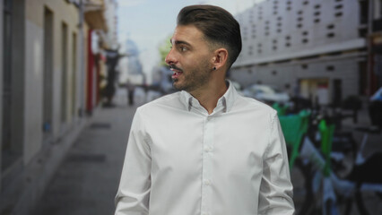 Obraz premium Man in white shirt shrugs shoulders on narrow crowded city street lined with parked scooters; uncertainty confusion.