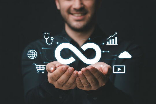 Smiling man presents an infinity loop symbol with various icons representing healthcare global connectivity ecommerce data analytics cloud computing and video streaming on a dark background - Powered by Adobe
