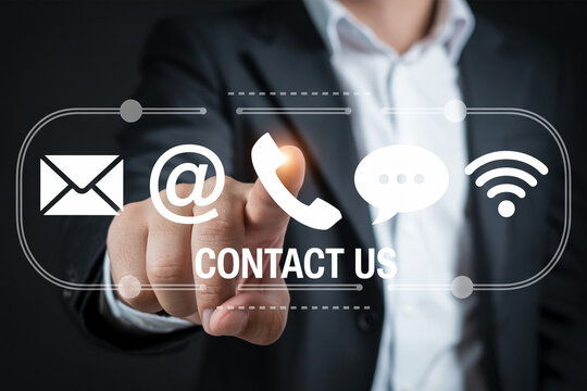 Businessman touching contact us icons on a virtual screen featuring email phone chat and wifi symbols for customer service and communication in a modern business setting for support and assistance