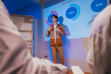 young Asian software development manager leads a late-night office discussion with his executive team, mentoring developers and analyzing source code to guide programming and project development	