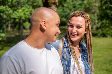 Fototapeta premium Young couple enjoying a joyful moment outdoors, with a lush green background, showcasing their happy relationship and shared goals in a beautiful natural setting