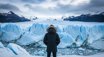 Person in Warm Coat Standing in Front of Glacial Ice Field in Cold Polar Environment