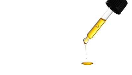 Dropper dispensing a golden liquid with a drop falling against a stark black background