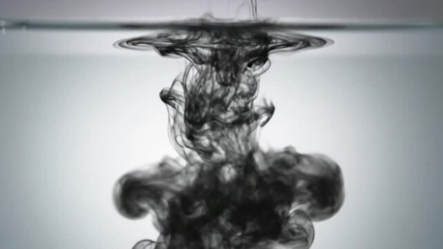 Black ink gracefully dissolves in clear water, forming dynamic abstract patterns