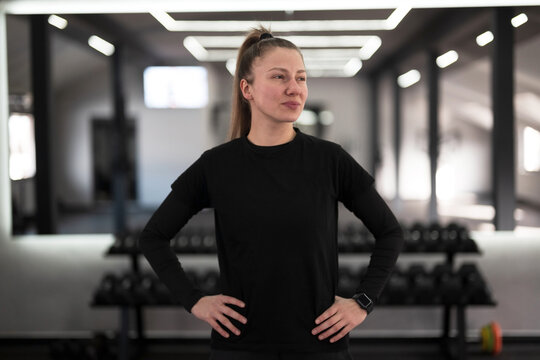 Confident fitness enthusiast prepares for workout in modern gym setting