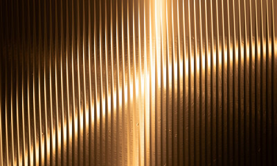 Warm golden light reflecting off a textured ribbed metal panel