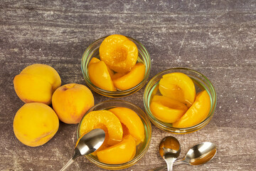 Half-cut peaches, canned preserve. Close-up photograph with copy space on a rustic background.