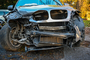 Heavily damaged car front end showing impact, bent metal, and ruptured radiator