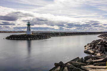 Serene view of Prescott Marina and lighthouse on the St. Lawrence River, capturing the tranquil ambiance of Ontario's riverside beauty.