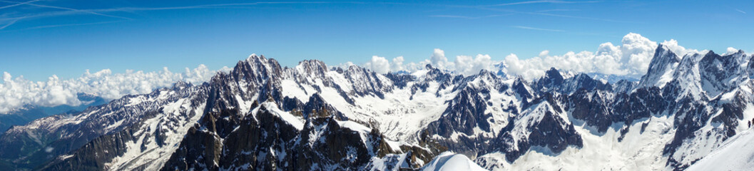 A view of a ridge of jagged, high, snow-covered mountains in the French Alps Photo taken from the Aiguille du Midi mountain Chamonix large snow cover with footprints is visible
