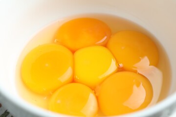 Fresh egg yolks in bowl, closeup view