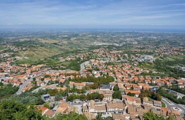 Fototapeta premium Panoramic view from San Marino over the urban landscape and the distant hazy Adriatic Sea.