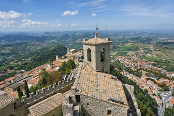Obraz premium High-angle view of a San Marino tower and fortified battlements overlooking the surrounding landscape.