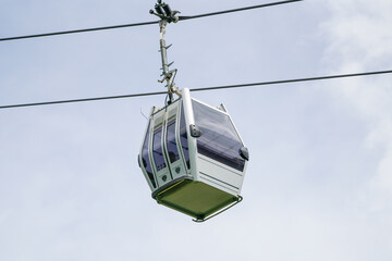 A small white and silver box is suspended from a cable